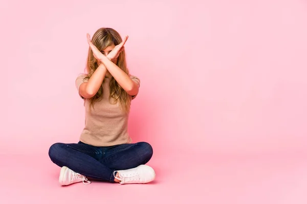 Mladá Blondýnka Běloška Sedící Růžovém Studiu Zkříženýma Rukama Popírající Koncept — Stock fotografie