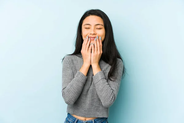 Joven Mujer China Aislada Sobre Fondo Azul Riendo Algo Cubriendo —  Fotos de Stock