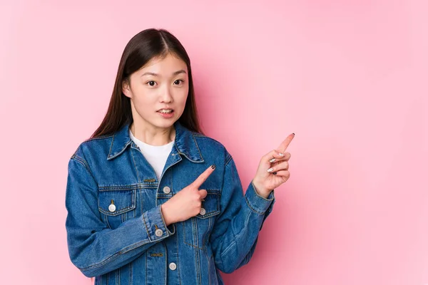 Mulher Chinesa Jovem Posando Fundo Rosa Isolado Chocado Apontando Com — Fotografia de Stock
