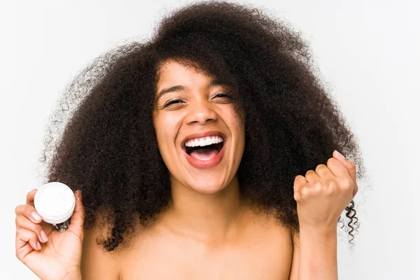 Jovem Afro Mulher Segurando Hidratante Isolado Torcendo Despreocupado Animado Conceito — Fotografia de Stock