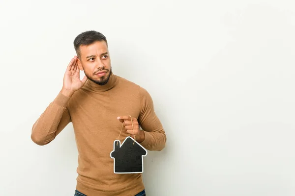 Young South Asian Man Holding Home Icon Trying Listening Gossip — Stock Photo, Image