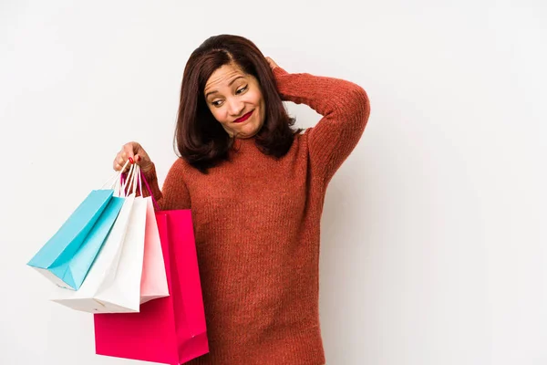 Medelålders Latinamerikansk Kvinna Håller Shoppingpåse Isolerad Vidröra Baksidan Huvudet Tänka — Stockfoto