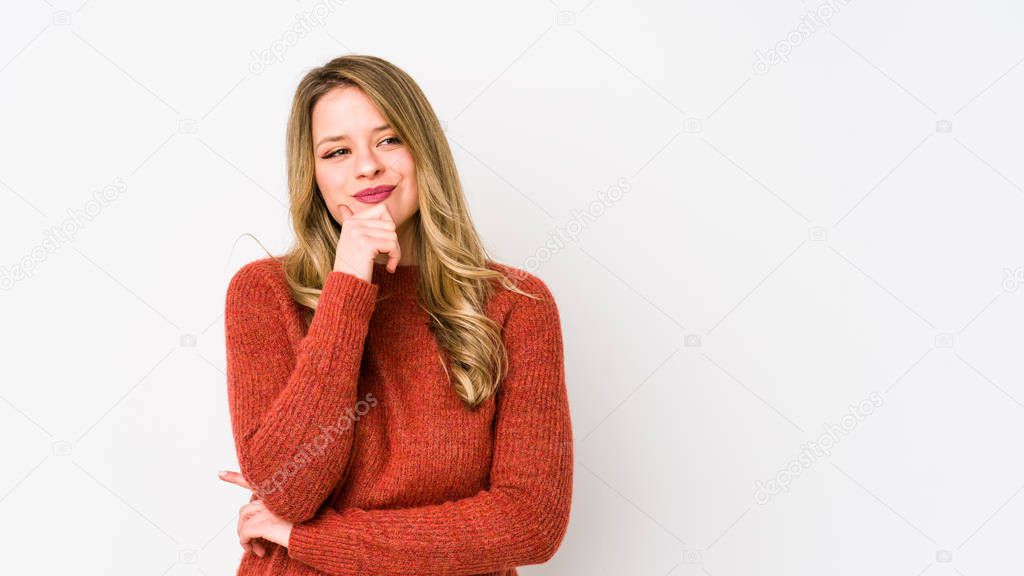 Young caucasian woman isolated on white background relaxed thinking about something looking at a copy space.