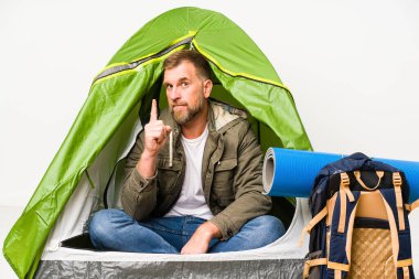 Beyaz arka planda izole edilmiş bir çadırın içinde bir numara parmağıyla görünüyor..