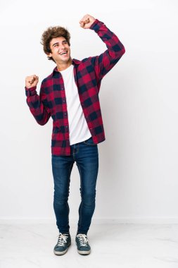 Tam vücut Kafkasyalı genç adam zaferden sonra yumruğunu kaldırıyor, kazanan konsept..