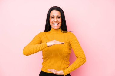 Pembe arka planda izole edilmiş beyaz bir kadın iki eliyle bir şey tutuyor, ürün sunumu..