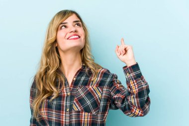 Sarışın, beyaz bir kadın iki elini de havaya kaldırarak boş bir alan gösterdiğini gösteriyor..