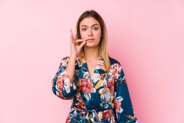 Genç beyaz kadın pijama giyiyor parmakları dudaklarında sır saklıyor..