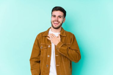 Genç yakışıklı adam elini göğsüne koyarak kahkahalar atıyor..