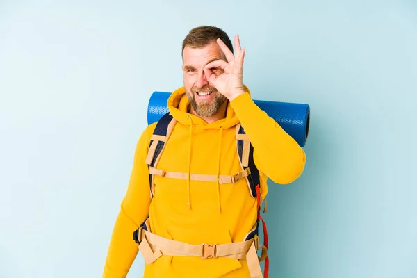 Starszy Turysta Człowiek Odizolowany Niebieskim Tle Podekscytowany Utrzymanie Gest Oko — Zdjęcie stockowe