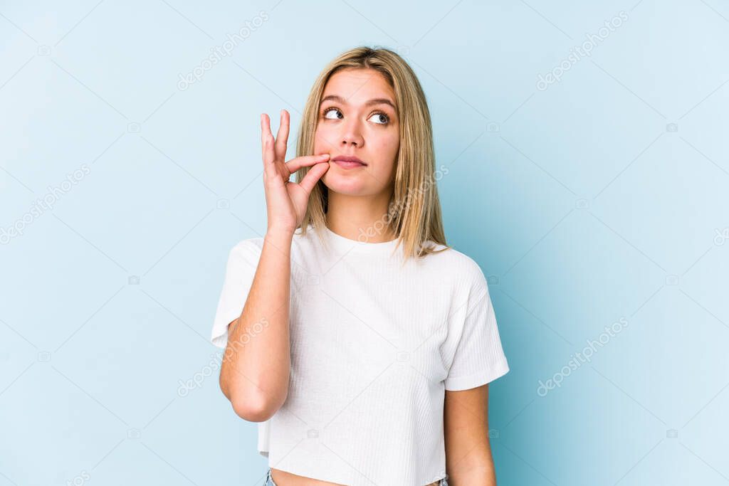 Young blonde caucasian woman isolated with fingers on lips keeping a secret.