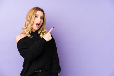 Sarışın genç bir kadın, tek başına kenarı gösteriyor.