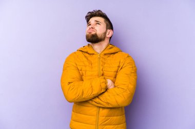 Mor arka planda izole edilmiş genç beyaz adam tekrarlanan bir görevden bıktı..