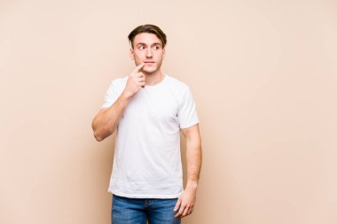 Kafkasyalı genç adam yalnız poz veriyor. Şüpheli ve şüpheci bir ifadeyle yana bakıyor..