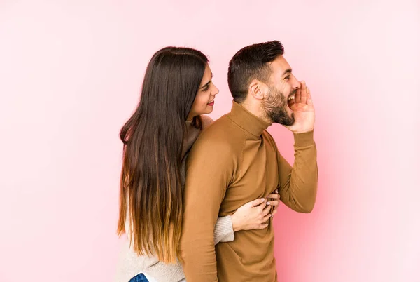 Young Caucasian Couple Isolated Shouting Holding Palm Opened Mouth — Stock Photo, Image