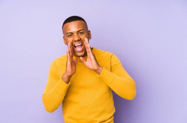 Mor arka planda izole edilmiş genç latin adam heyecanla bağırıyor..