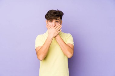 Mor arka planda izole edilmiş genç bir Arap adam elleriyle ağzını kapatırken şok oldu..