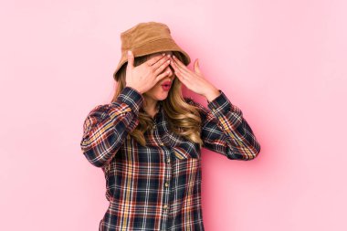Şapka takan genç, beyaz bir kadın izole edilmiş, elleri ile gözleri kapatmaktan korkuyor..