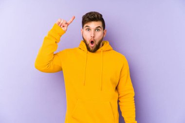 Mor arka planda izole edilmiş genç bir adamın yaratıcılık kavramı ve harika bir fikri var..