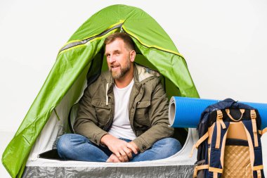 Beyaz arka planda izole edilmiş bir çadırın içinde gülümseyen, neşeli ve keyifli bir görünüm var..