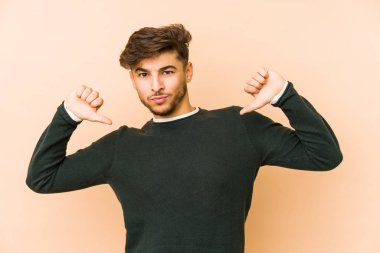 Bej bir arka planda izole edilmiş genç bir Arap gururlu ve kendinden emin hissediyor, örnek olarak..