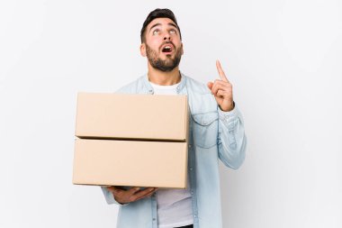 Kafkasyalı genç bir adam yeni evine taşınıyor yalnız, ağzı açık, üst tarafı işaret ediyor..