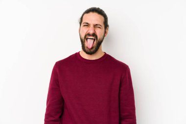 Genç, uzun saçlı, beyaz bir arka planda izole edilmiş komik ve dostça bir dille konuşan adam..