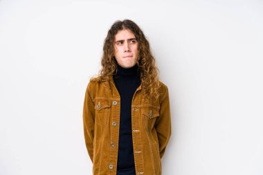 Uzun saçlı adam yalnız poz veriyor. Kafası karışık, kararsız ve kararsız..