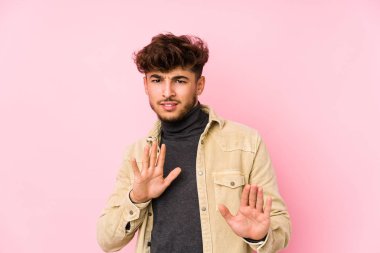 Arka planda poz veren genç bir Arap, tiksinti belirtisi gösteren birini reddediyor..