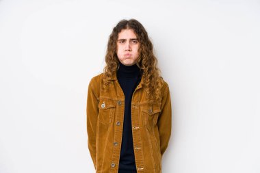 Uzun saçlı adam yalnız poz veriyor, yanakları patlatıyor, yorgun bir ifadesi var. Yüz ifadesi kavramı.