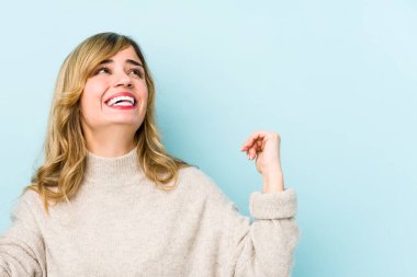 Genç sarışın, beyaz kadın zafer kazandıktan sonra yumruğunu kaldırıyor..