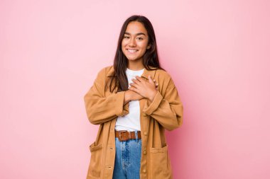 Karma ırklı genç bir Hintli kadın dost canlısı bir ifadeye sahip, avuçlarını göğsüne bastırıyor. Aşk konsepti.