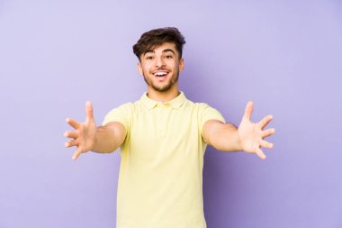 Mor arka planda izole edilmiş genç bir Arap adam kameraya sarıldığı için kendinden emin hissediyor..