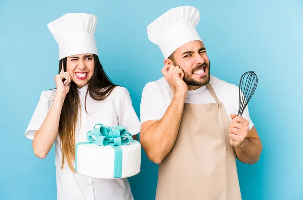 Jeune Couple Cuisinant Gâteau Ensemble Isolé Couvrant Les Oreilles Avec — Photo