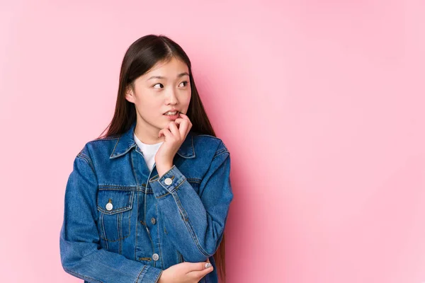 Joven Mujer China Posando Fondo Rosa Aislado Relajado Pensando Algo —  Fotos de Stock