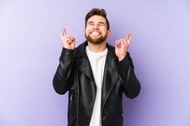 Mor arka planda izole genç adam şans dilemek için şans diliyor.