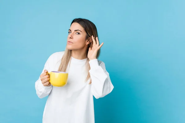 Joven Mujer Caucásica Sosteniendo Una Taza Café Tratando Escuchar Chisme — Foto de Stock