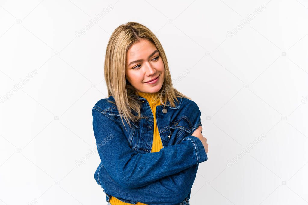 Young blonde caucasian woman isolated hugs, smiling carefree and happy.