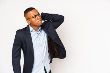 Genç iş adamı beyaz arka planda izole edilmiş. Kafasının arkasına dokunuyor, düşünüyor ve bir seçim yapıyor..