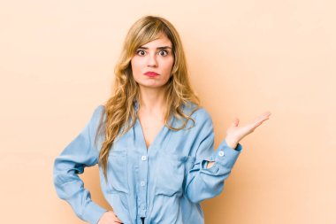 Sarışın, beyaz bir kadın avucunun içinde fotokopi odası gösteriyor ve başka bir eli belinde tutuyor..