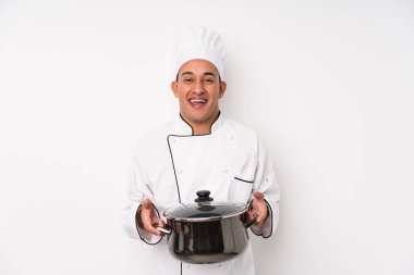 Genç aşçı Latin adam yemek yapıyor.