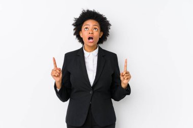 Orta yaşlı Afrikalı Amerikalı iş kadını beyaz bir arka plana karşı ağzı açık, üst tarafı göstererek izole edilmiş..