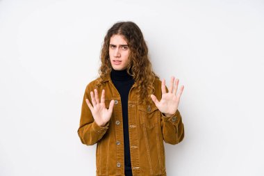 Uzun saçlı adam yalnız poz veriyor. İğrenme belirtisi gösteren birini reddediyor..