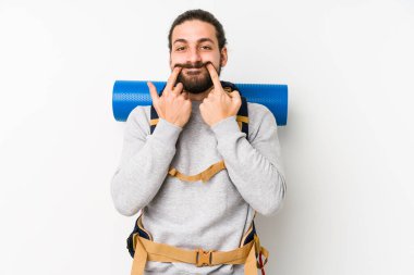 Genç bir sırt çantalı adam iki seçenek arasında şüphe duyan beyaz bir arka planda izole edilmiş..