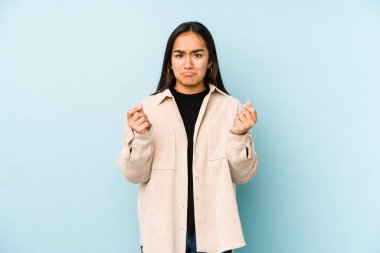 Mavi arka planda izole edilmiş genç bir kadın hiç parası olmadığını gösteriyor..