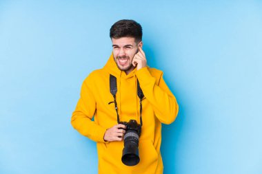 Kafkasyalı genç fotoğrafçı kulaklarını elleriyle kapatıyor..