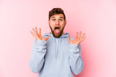 Pembe arka planda izole edilmiş genç beyaz adam gökyüzüne haykırıyor, yukarı bakıyor, hayal kırıklığına uğramış..