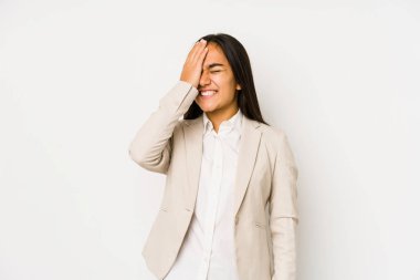 Beyaz bir arka planda izole edilmiş genç bir kadın bir şeyi unutuyor. Alnına avuç içi ile vuruyor ve gözlerini kapıyor..