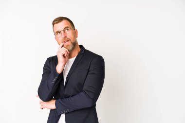 Beyaz arka planda izole edilmiş kıdemli iş adamı rahatlamış bir şeyin fotokopi odasına baktığını düşünüyor..