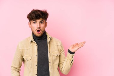 Arka planda poz veren genç bir Arap, avuç içi fotokopi alanı tutmaktan etkilenmiş..